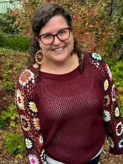 An image of a white woman in a burgundy shirt